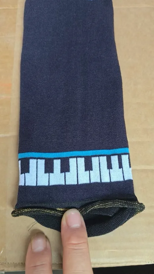 Piano keyboard knitted into a sock — the 2-3 grouping is what makes it read as a real piano